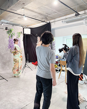 黒いトレイに整然と並べられた色鮮やかな帯締めのコレクション。赤と金色の市松模様、紫と金色の市松模様、水色に金色の花柄、ピンクの房付きなど、多様な色と柄の帯締めが見られる。