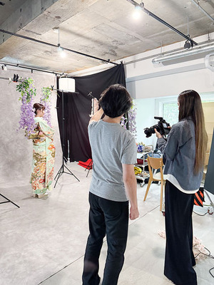 黒いトレイに整然と並べられた色鮮やかな帯締めのコレクション。赤と金色の市松模様、紫と金色の市松模様、水色に金色の花柄、ピンクの房付きなど、多様な色と柄の帯締めが見られる。