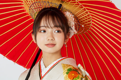 赤い和傘を差した振袖姿の女性