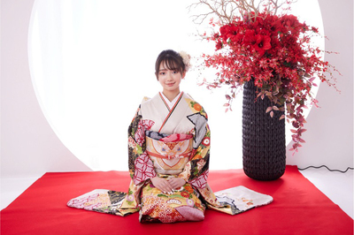 成人式の白い振袖を着て赤い毛氈の上に正座する女性のポートレート