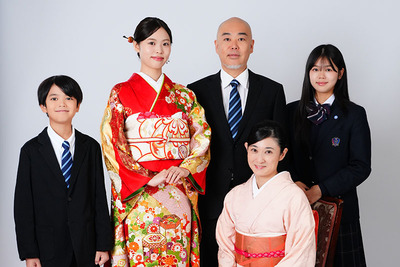 黄色い振袖をなびかせながら、屋外の街灯の横で笑顔を見せる女性のロケーションフォト